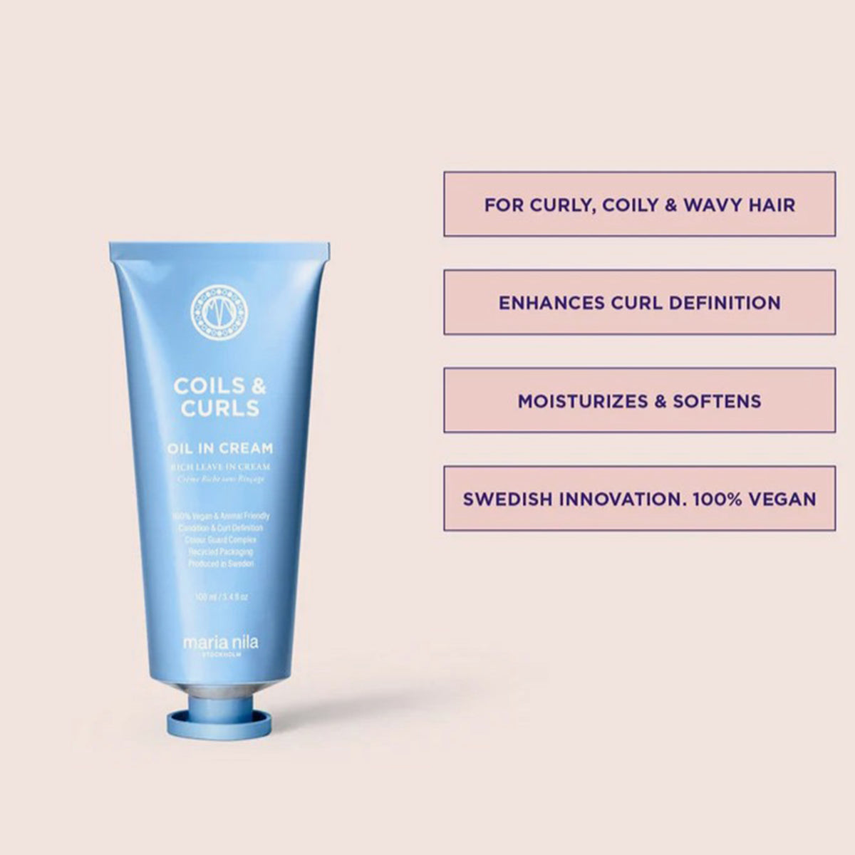 Blaue Tube Coils & Curls Oil In Cream aus der Coils & Curls Beauty Bag 2025, neben Produktvorteilen auf blassrosa Hintergrund.