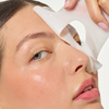 Eine Frau schält die Mario Badescu Advanced Collagen Hydrogel Mask 3 Pack ab und enthüllt glatte, strahlende Haut.