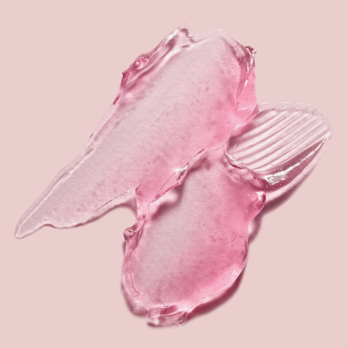 Nahaufnahme einer rosafarbenen, transparenten Geltextur der medicube Collagen Jelly Cream auf hellem Hintergrund.