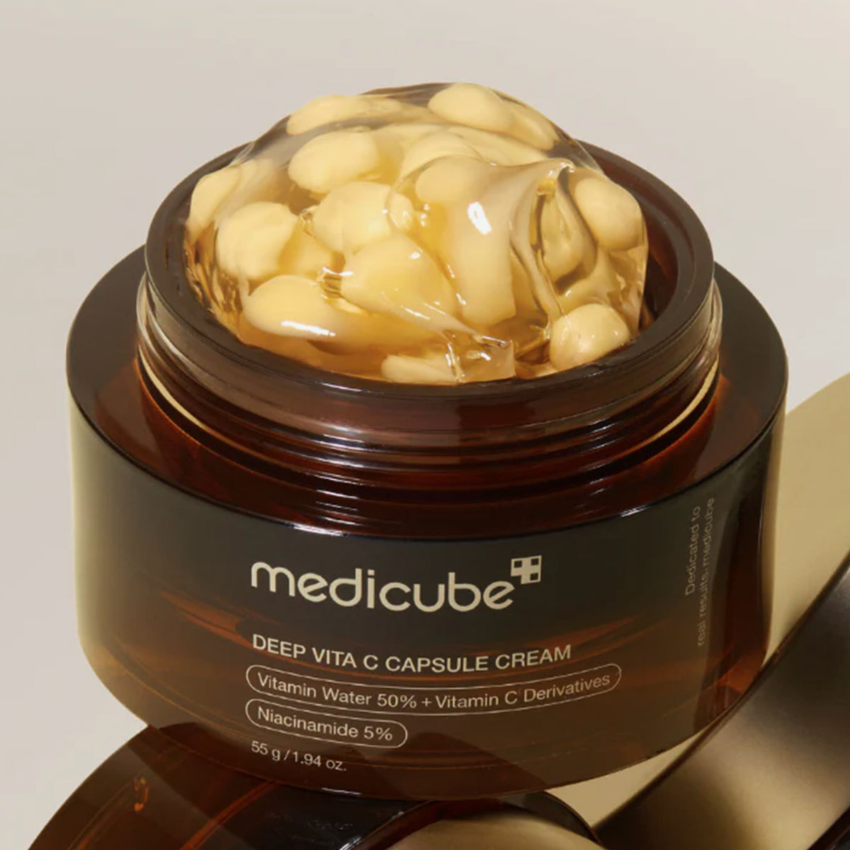 Brauner Tiegel der Medicube Deep Vita C Capsule Cream, geöffnet mit sichtbaren gelben Kapseln in Geltextur, Nahaufnahme des Produkts.