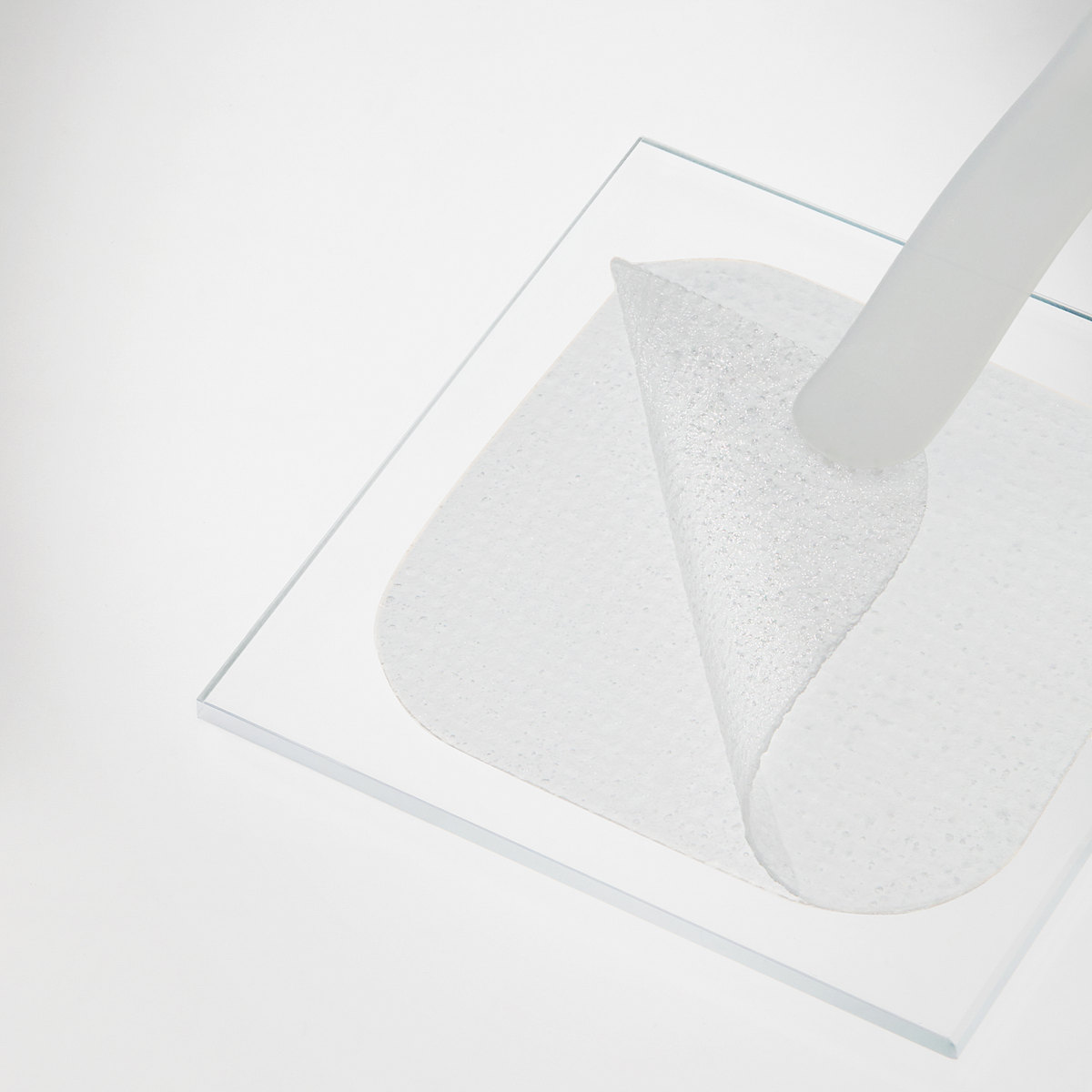 Ein „Mediheal Hyaluronate Hydration Pad“ wird von einer durchsichtigen, quadratischen Oberfläche vor einem weißen Hintergrund abgezogen.
