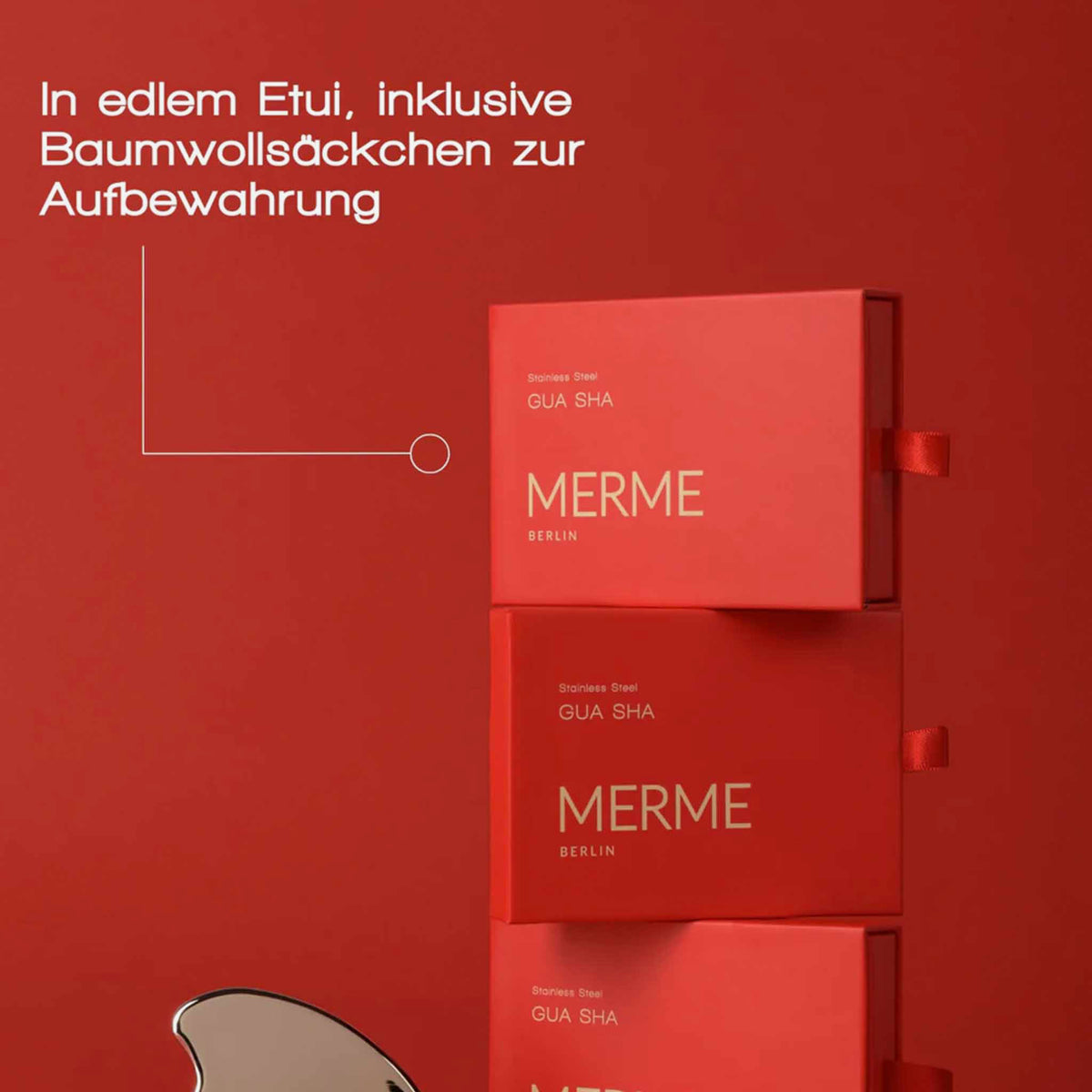 Drei MERME-Edelstahl-Gua-Sha-Boxen, gestapelt auf rotem Hintergrund, mit deutschem Text über Aufbewahrungsbeutel aus Baumwolle.