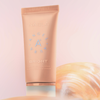 Pfirsichfarbene Tube der NABLA Cosmetics Angel Aura Bright auf zartrosa Hintergrund.