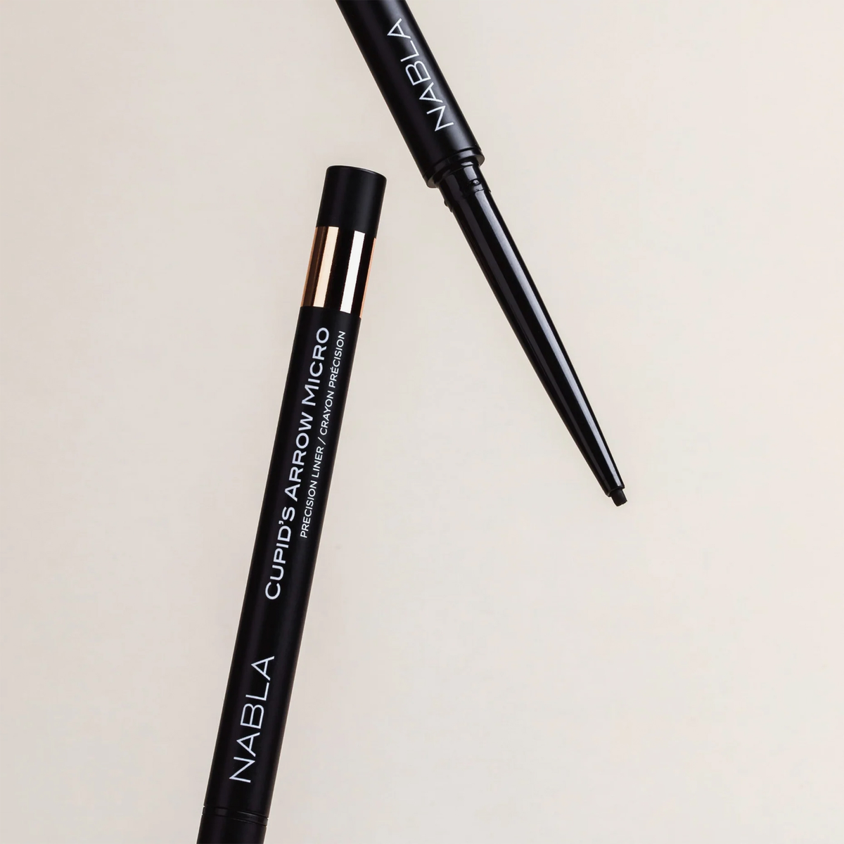 Zwei schwarze NABLA Cosmetics Cupids Arrow Micro Eyeliners: einer mit Kappe, einer mit freiliegender Spitze.