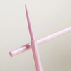 Ein rosafarbener NABLA Cosmetics Cupids Arrow Micro Bleistift mit ausgezogener Spitze, auf einem passenden geschlossenen Bleistift platziert.