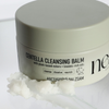 Ein Tiegel mit NERDS. Centella Cleansing Balm mit etwas Balsam, der herausgeschöpft und vor den Behälter gestellt wurde.