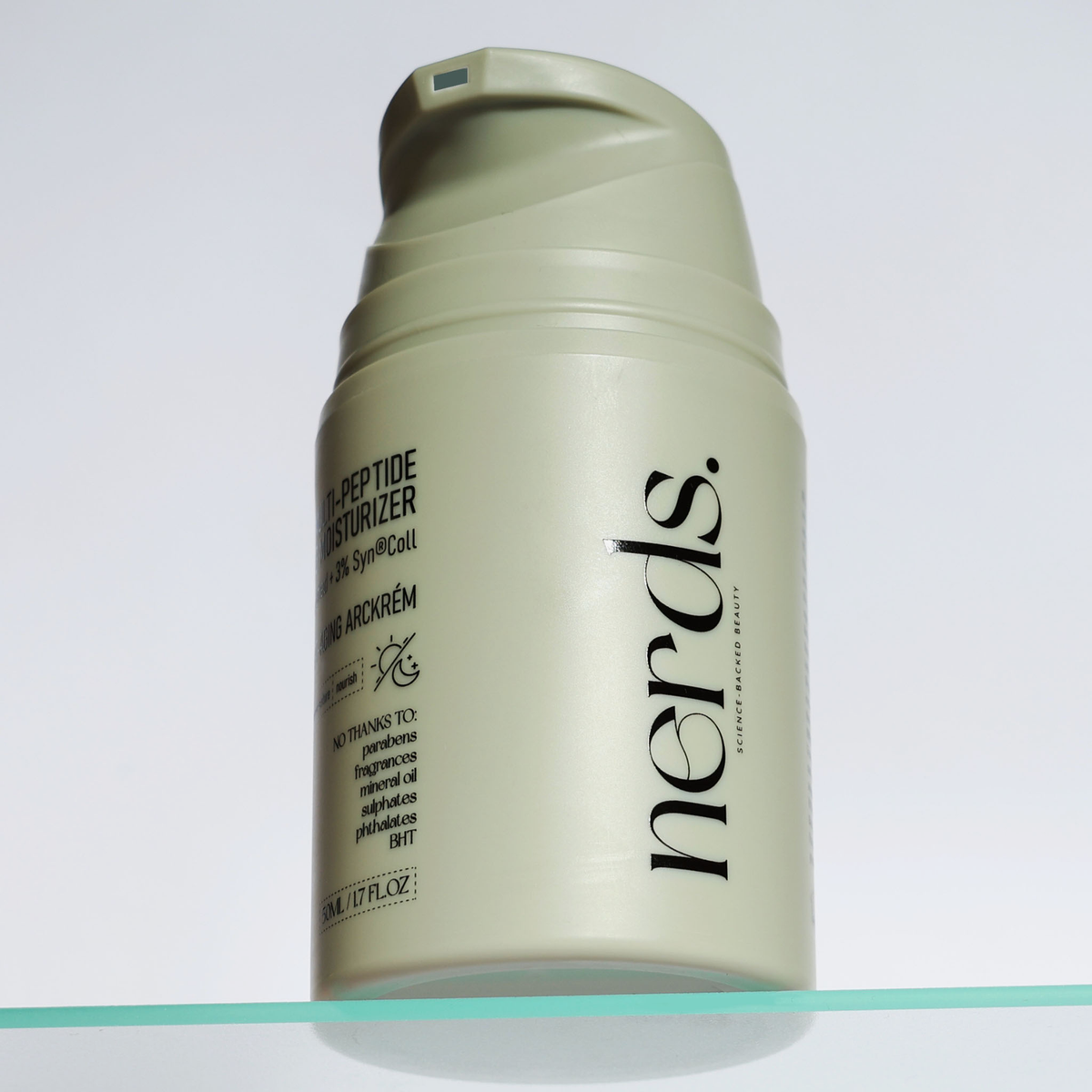 NERDS. Multi-Peptide Smart-Aging Moisturizer in einer hellgrünen Flasche mit Pumpspender, ausgestellt in einem Klarglasregal.