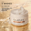 Ein geöffneter Tiegel der OLAPLEX Rich Hydration Mask steht auf einer goldenen, nassen Oberfläche; daneben Produktvorteile.