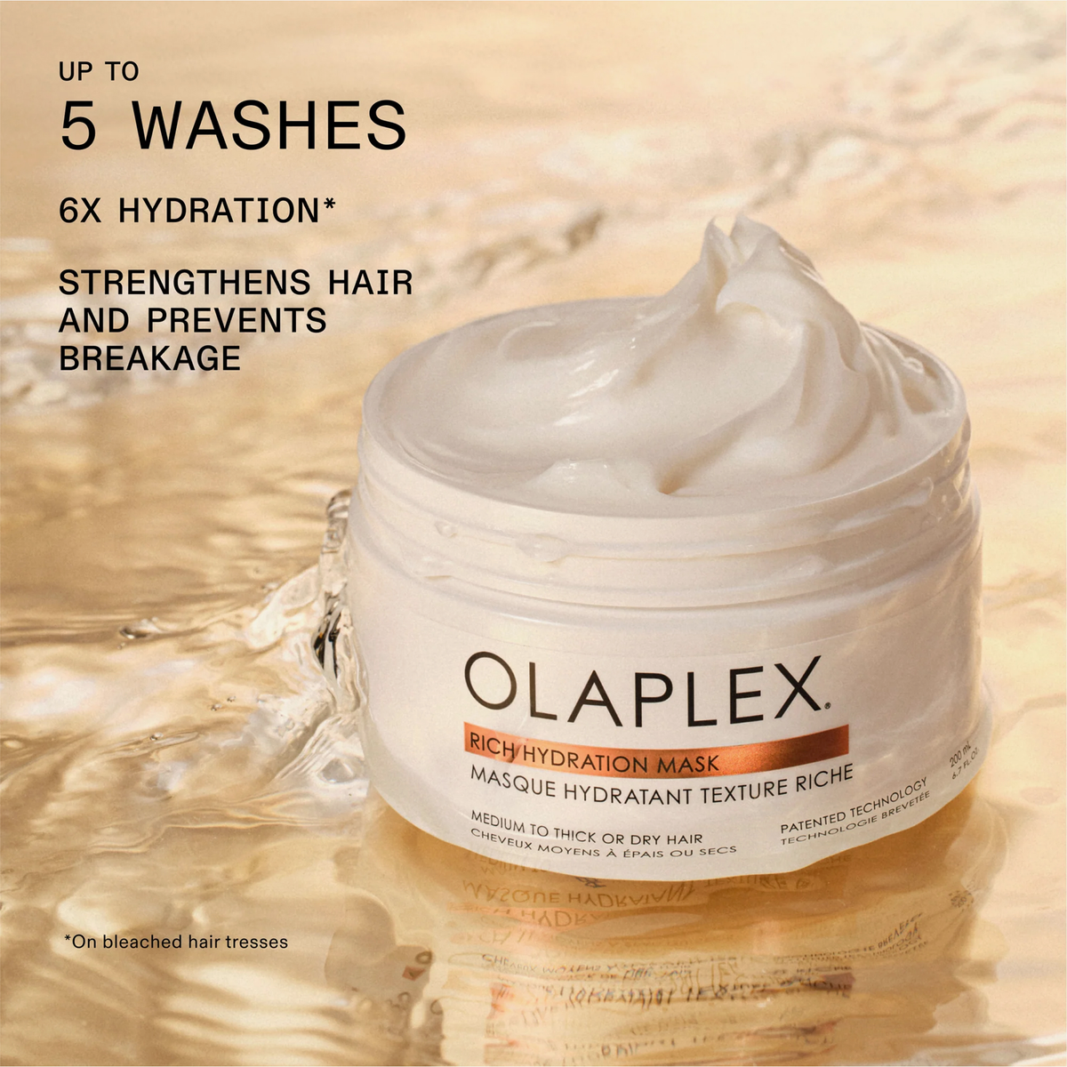 Ein geöffneter Tiegel der OLAPLEX Rich Hydration Mask steht auf einer goldenen, nassen Oberfläche; daneben Produktvorteile.