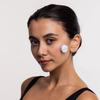 Eine Frau mit dunklem Haar posiert vor einem schlichten Hintergrund und trägt das STYLPRO LED Spot & Blemish Patch Hautpflegegerät auf der Wange.