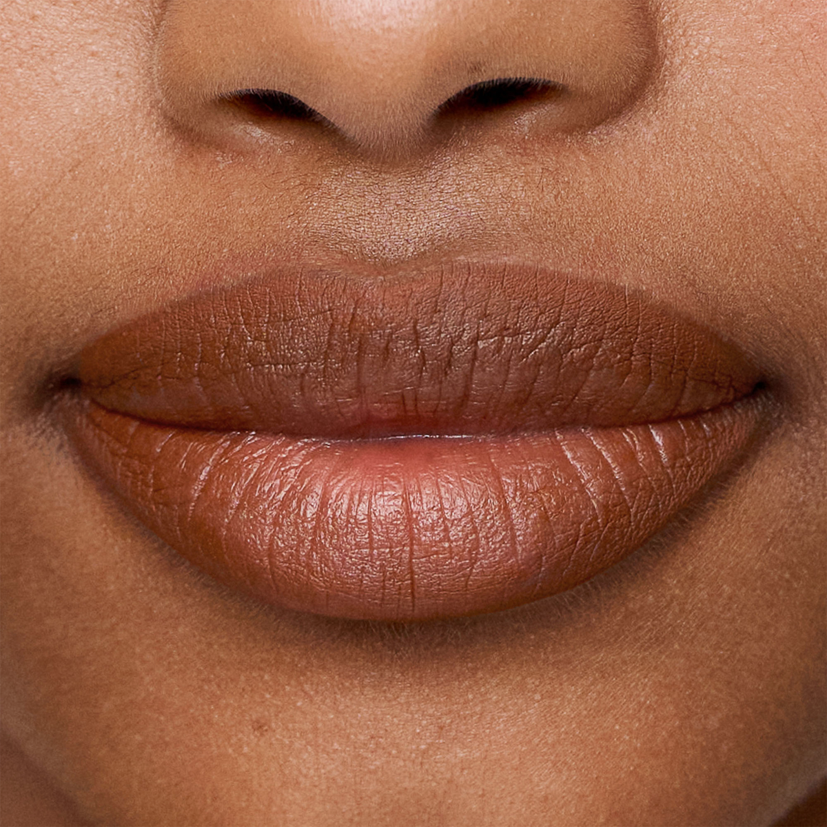Nahaufnahme von glatter, brauner Haut und natürlichen Lippen, die mit dem SWEED Lip Liner konturiert wurden.