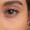 Nahaufnahme eines braunen Auges mit langen Wimpern und markanten Augenbrauen, das sich durch glatte Haut auszeichnet; für einen natürlichen Look wurde „SWEED The Brow Serum“ verwendet.
