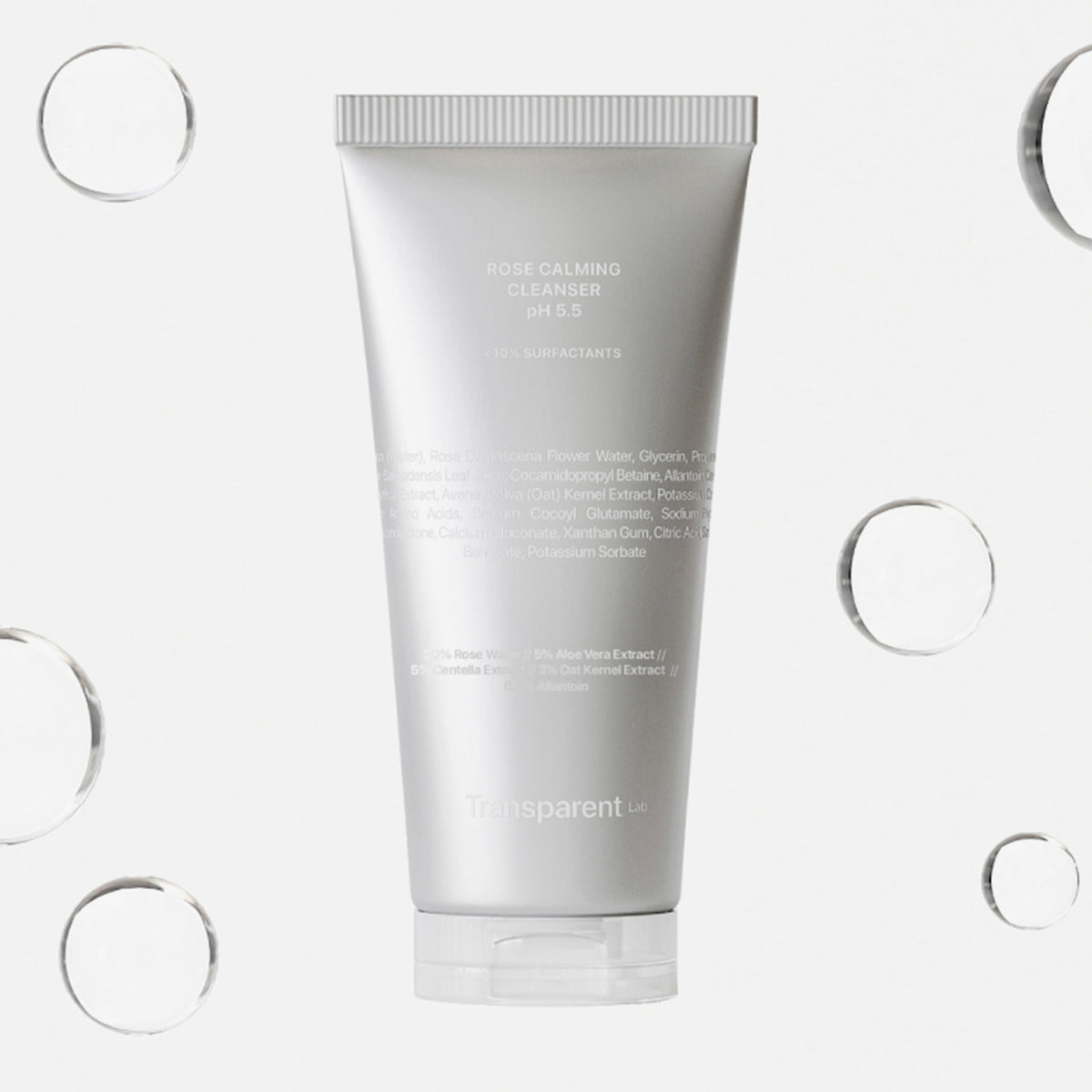 Eine silberne Tube „Rose Calming Cleanser pH 5.5“ ist von durchscheinenden Blasen auf weißem Hintergrund umgeben.