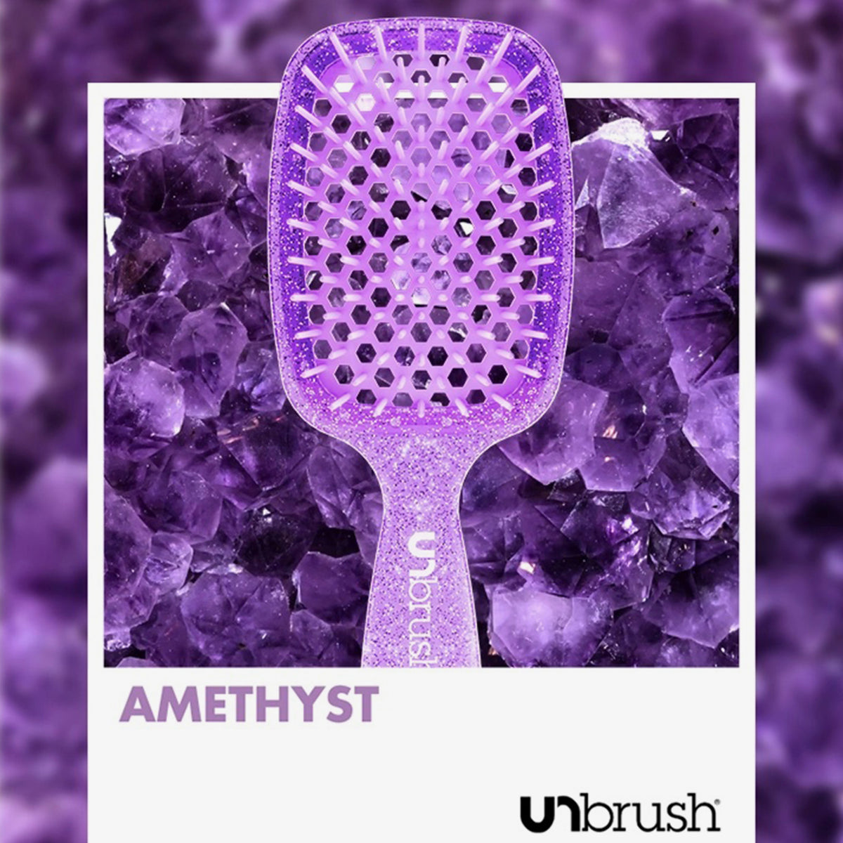 Die Detangling Hair Brush von UNbrush in Amethyst wird vor einem Hintergrund aus Amethystkristallen präsentiert.