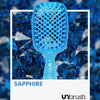 UNbrush Detangling Hair Brush in Sapphire, vor einem Hintergrund aus blauen Edelsteinen.