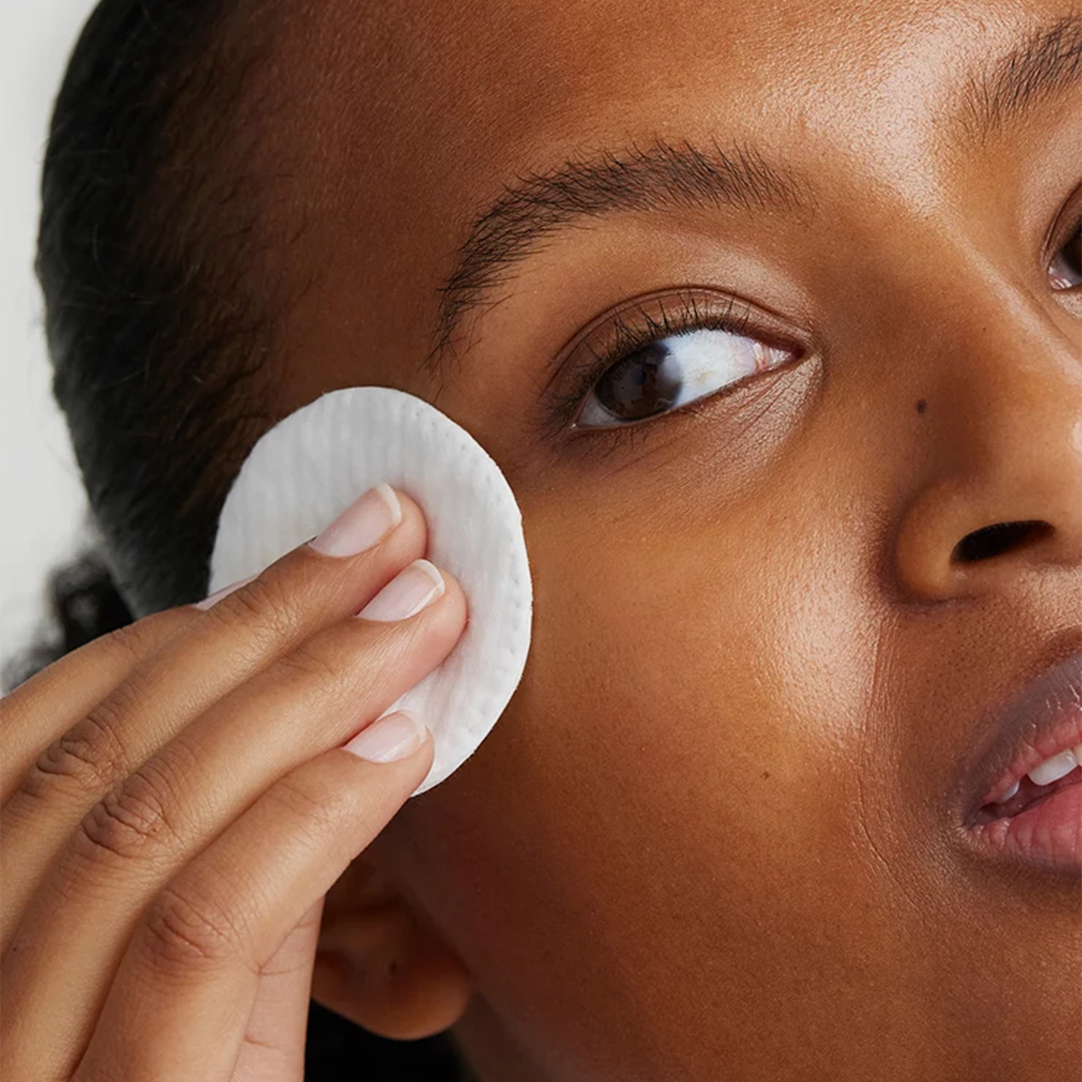Eine Person verwendet ein XLASH Caring Eyes-Pad, um Make-up im Augenbereich sanft zu entfernen und dabei die empfindliche Haut zu schonen.
