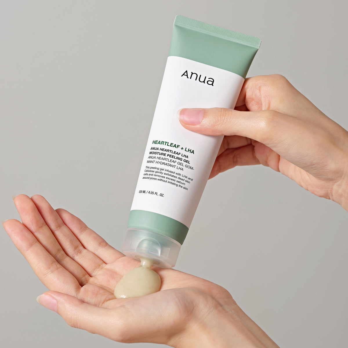 Eine Person drückt Heartleaf LHA Moisture Peeling Gel aus einer Anua-Hautpflegetube auf ihre Handfläche.