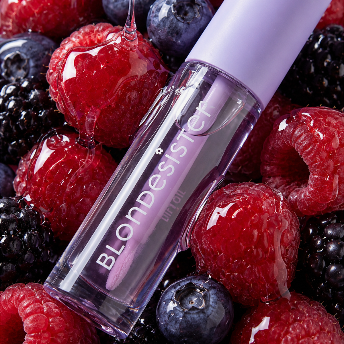 Eine Tube „BLONDESISTER 3 IN 1 CUTE LIPPY LIP OIL“ mit dem Duft von saftigen Himbeeren, Brombeeren und Heidelbeeren, übergossen mit glänzendem Sirup.