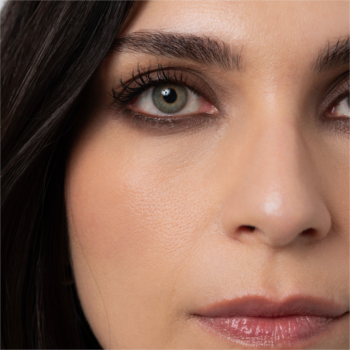 Nahaufnahme einer Frau mit grünen Augen, langen Wimpern und glatter Haut, die den BLONDESISTER 3 IN 1 EYES ON ME Lidschatten, Eyeliner und Kajal trägt.