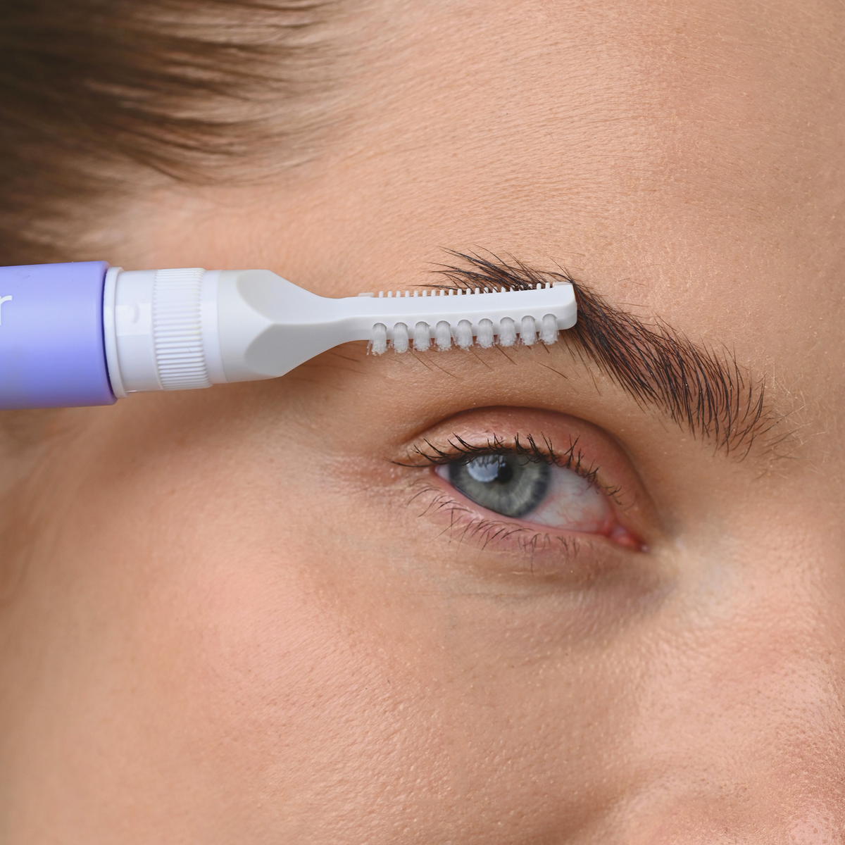 Eine Nahaufnahme einer Person, die ihre Augenbrauen mit dem „3 IN 1 FIX&GO BROW GEL“ von BLONDESISTER in Form bringt.