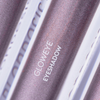Nahaufnahme des BLONDESISTER GLOWEYE EYESHADOW in einer metallisch-mauvefarbenen Verpackung, auf der der Produktname in fetten weißen Buchstaben steht.