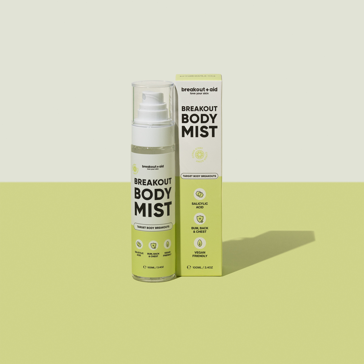 Eine durchsichtige Breakout Body Mist-Sprühflasche und die dazugehörige Verpackung, beide mit den wichtigsten Inhaltsstoffen und Anwendungsmöglichkeiten beschriftet.