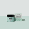Ein Tiegel Breakout Body Scrub neben seiner quadratischen Verpackung; auf beiden sind auf den Etiketten Salicylsäure, Glykolsäure, Squalan und Aloe Vera aufgeführt.
