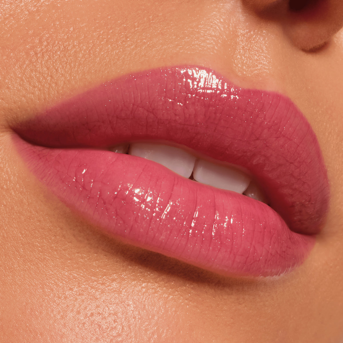 Nahaufnahme glänzender Lippen in einem zarten Rosaton, geschminkt mit dem Catrice Diamond Glaze Gloss Stick für ein glänzendes Finish.