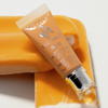 Eine Tube Danessa Myricks Beauty Colorfix Pastels Dreamsicle in orange liegt auf einem orange-weißes Eis am Stiel.
