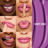 Sechs Frauen mit glänzenden violetten Lippen posieren; Text: „Glosswork 4D Ultra Shine Plumping Gloss von Danessa Myricks Beauty.“.