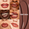Sechs Nahaufnahmen von glänzenden braunen Lippen, der Schriftzug „HONEY COCOA“ und ein Gloss-Fleck zeigen den „Glosswork 4D Ultra Shine Plumping Gloss“ von Danessa Myricks.