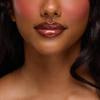 Eine Nahaufnahme von glänzenden Lippen, glatter Haut und rosigen Wangen dank des Juicy Lip Balm von Dominique Cosmetics.