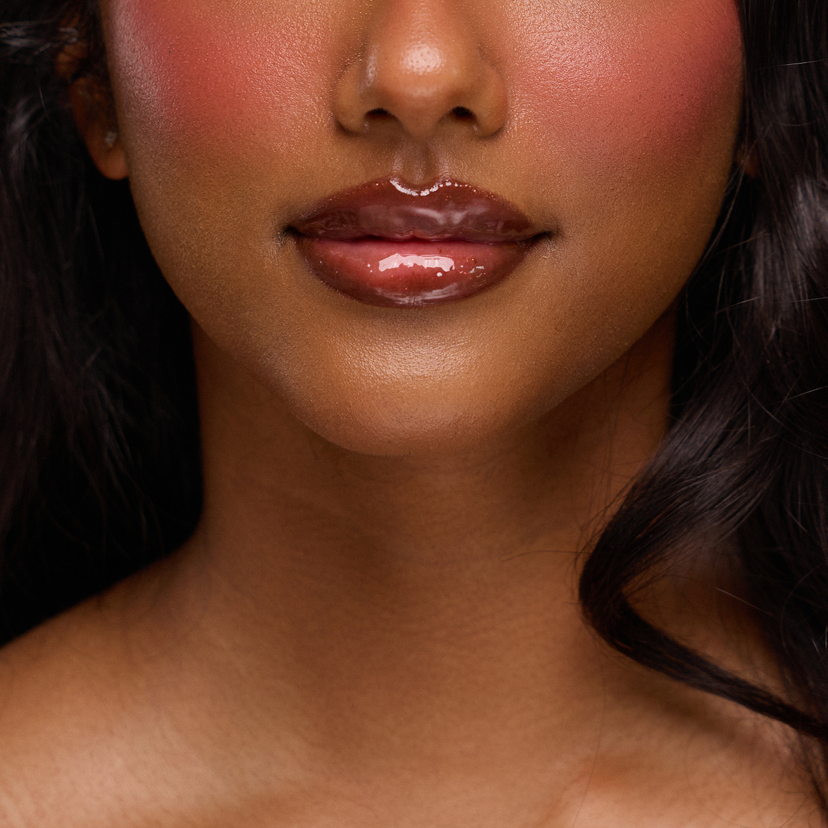 Eine Nahaufnahme von glänzenden Lippen, glatter Haut und rosigen Wangen dank des Juicy Lip Balm von Dominique Cosmetics.