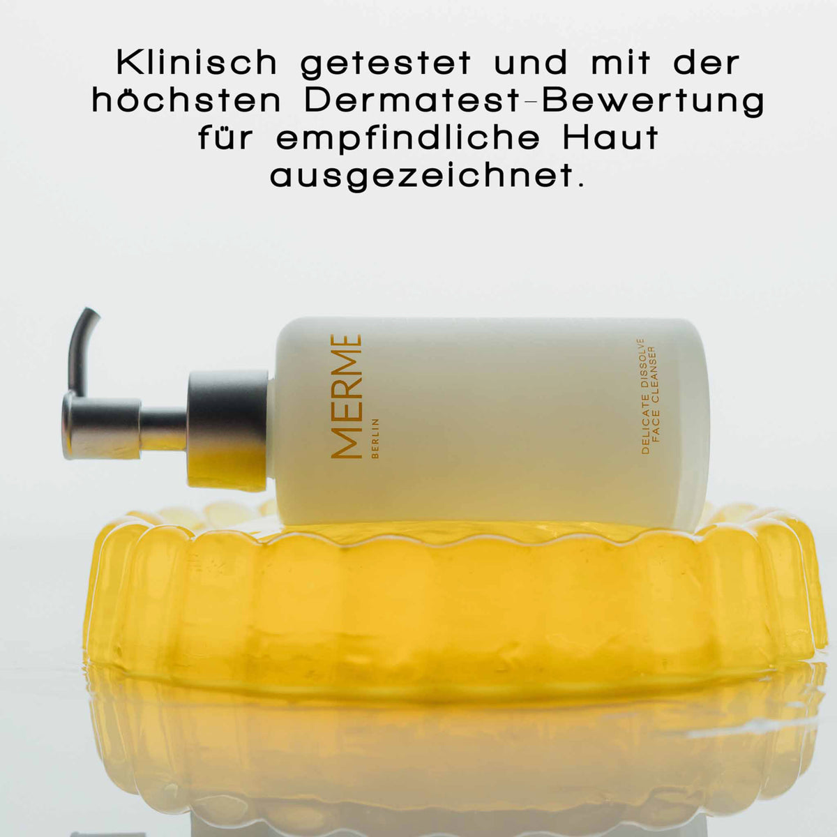 MERME Delicate Dissolve Face Cleanser liegt quer auf gelber Jelly-Form. Text: „Klinisch getestet und mit höchster Dermatest-Bewertung für empfindliche Haut ausgezeichnet“.