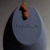 Ein NABLA Cosmetics Blended-up Multi-Angled Sponge, auf den flüssige Foundation gegossen wird.