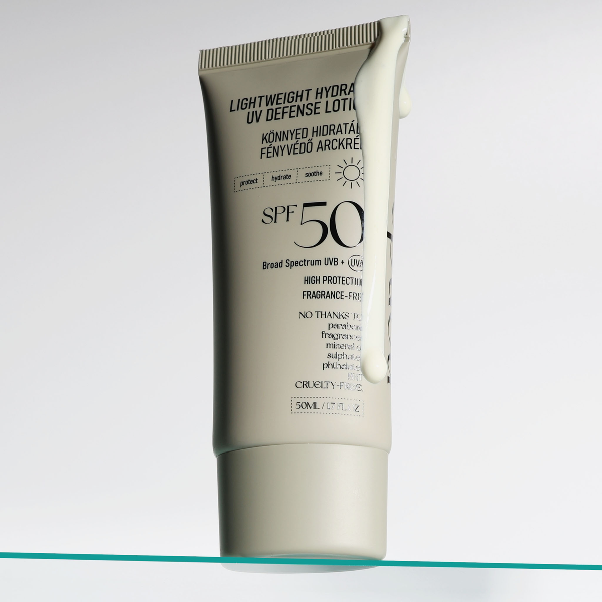 Eine Tube der NERDS. Lightweight Hydrate UV Defense Lotion SPF50, aus der etwas Lotion austritt, steht auf einer Glasfläche.