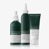 Drei grüne Flaschen der „Philip Kingsley Density Stimulating Mask“ sowie eine Tube stehen aufrecht auf einer weißen Fläche, wobei die Etiketten nach vorne zeigen.