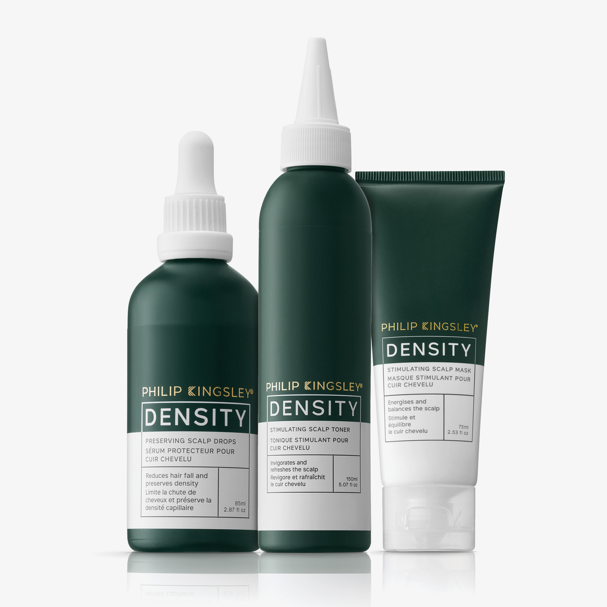 Drei grüne Flaschen der „Philip Kingsley Density Stimulating Mask“ sowie eine Tube stehen aufrecht auf einer weißen Fläche, wobei die Etiketten nach vorne zeigen.