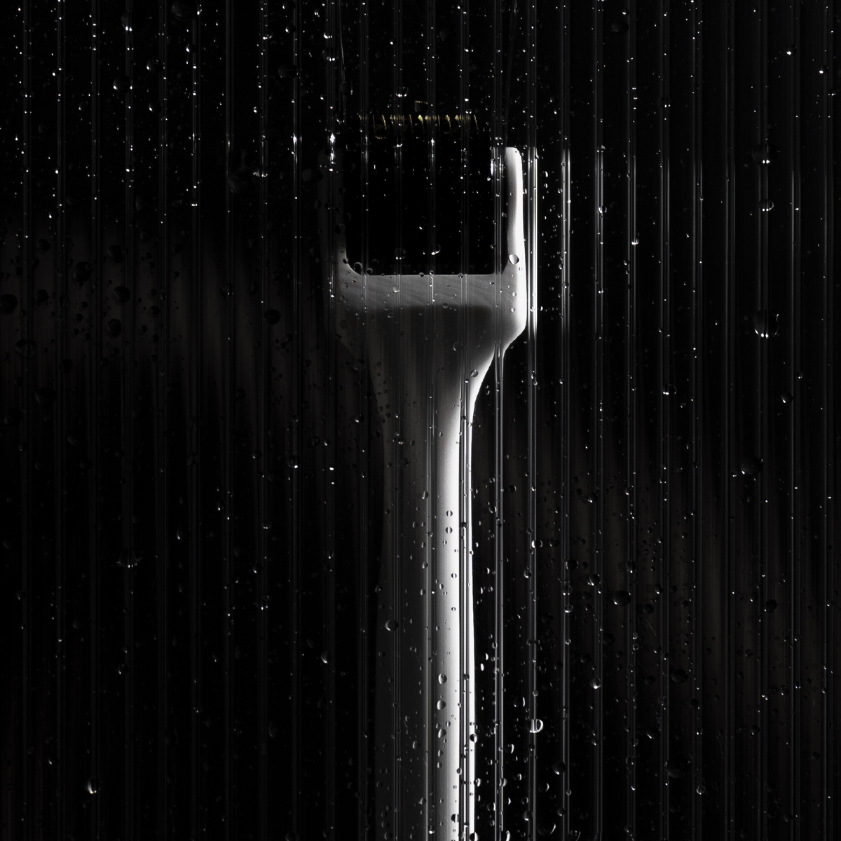 Der Scandinavian Biolabs Scalp Activation Derma Roller ist hinter einem nassen, geriffelten Glas mit Wassertropfen auf der Oberfläche abgebildet.