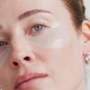 Nahaufnahme einer Frau, die XLASH Rejuvenating Eye Gels zur Pflege der Haut unter den Augen verwendet.