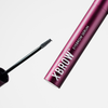 Eine metallic-rosa Tube mit der Aufschrift „XLASH Xbrow Eyebrow Serum“ und einem Applikatorpinsel vor weißem Hintergrund.
