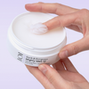 Eine Hand, die den „Geek & Gorgeous Mighty Melt“ Reinigungsbalsam (150 ml) aus einem weißen Tiegel schöpft.