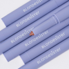 Sechs lavendelfarbene BLONDESISTER 3-IN-1-EYES-ON-ME-Stifte, von denen einer ohne Kappe ist und dessen nudefarbene Spitze sichtbar ist, diagonal auf einem weißen Hintergrund angeordnet.