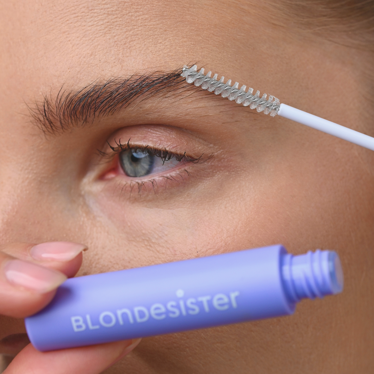 Eine Person trägt das 3 IN 1 FIX&GO BROW GEL von BLONDESISTER mit einer Spoolie-Bürste auf ihre Augenbrauen auf.