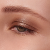 Nahaufnahme eines Auges mit dem Lidschatten „BLONDESISTER GLOWEYE“ in Metallic-Bronze und einer natürlichen, gepflegten Augenbraue.