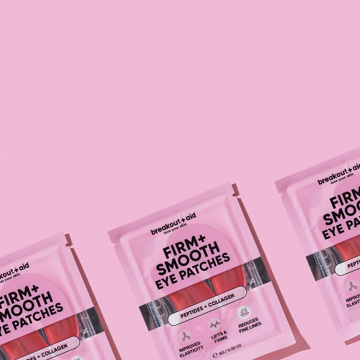 Drei rosa Tütchen mit Firm + Smooth – Hydrogel-Augenpads, die in einer Reihe vor einem rosa Hintergrund angeordnet sind.