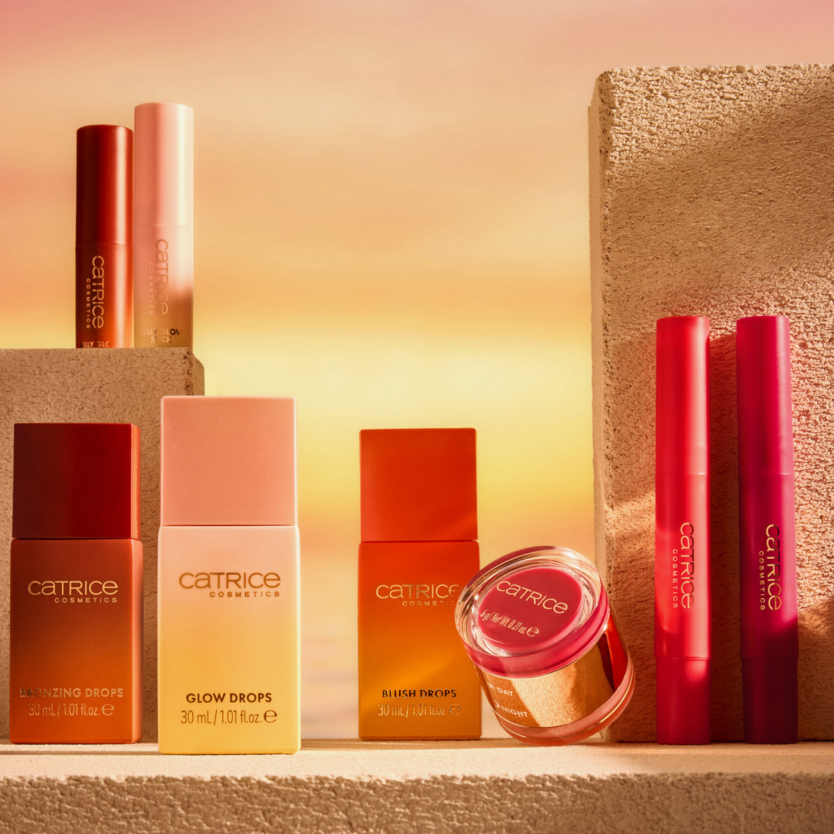 Die Catrice Cosmetics MIDNIGHT SUN Collection auf strukturierten Blöcken mit einem warmen Sonnenuntergang als Hintergrund.
