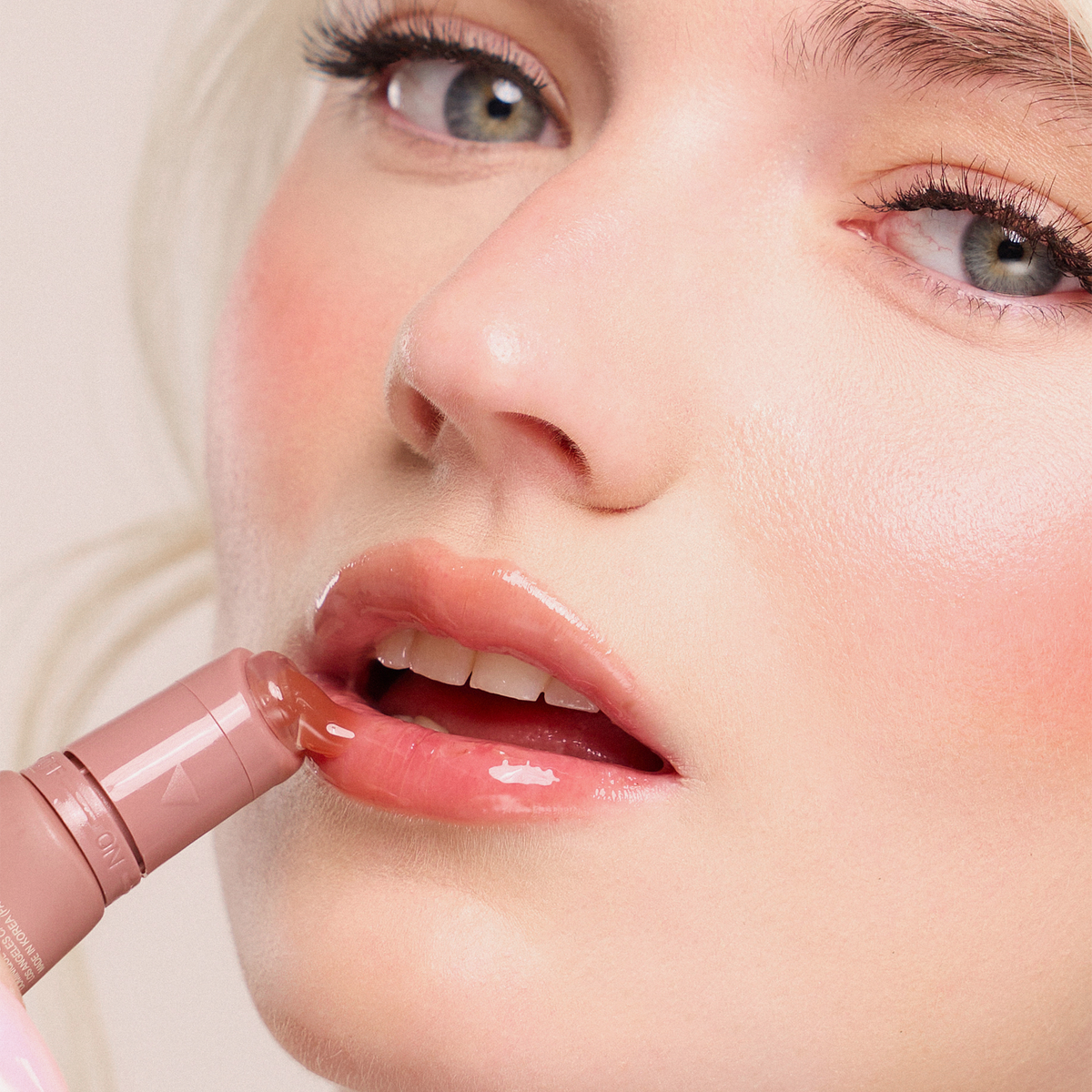 Eine Nahaufnahme glänzender Lippen, auf die Juicy Lip Balm von Dominique Cosmetics aufgetragen wird, um einen weichen, strahlenden Make-up-Look zu kreieren.