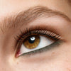 Nahaufnahme eines Auges mit olivgrünem Eyeliner am unteren Wimpernkranz, die Wimpern sind getuscht und das Auge wirkt wach und betont.
