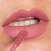 Nahaufnahme der Lippen mit „Over The Garden Wall“ von Lethal Cosmetics – aufgetragener „Scissors Velvet Liquid Lipstick“ von Adelaide, wobei der Applikator die Unterlippe berührt.